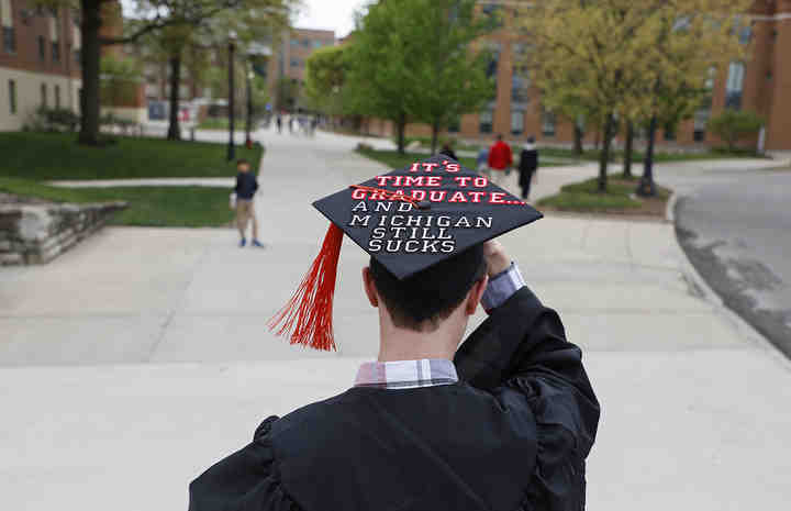 Ryan Kress of Loveland, adjusts his cap as he walks toward French Field House before the start of Ohio State University's 418th Commencement at Ohio Stadium in Columbus. Kress graduated with a B.S. in Mechanical Engineering.   (Joshua A. Bickel / The Columbus Dispatch)